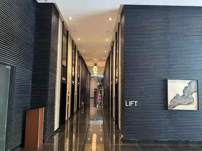 a hallway of a building with a woman walking down it at Air Residences - Balcony Pool View near Airport - 1721 in Manila