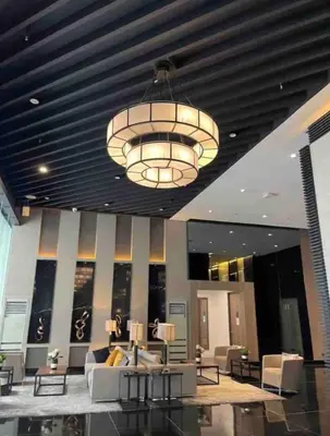 a large chandelier in a lobby with couches and tables at Air Residences - Balcony Pool View near Airport - 1721 in Manila