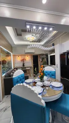 a dining room with a table and blue chairs at SMDC Coast Residences in Manila