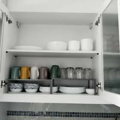 a kitchen cabinet filled with plates and bowls at SMDC Coast Residences in Manila