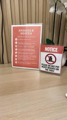 two signs sitting on top of a wooden table at Shore 2 Tower 3 in Manila