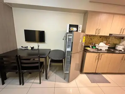 a small kitchen with a table and a refrigerator at Lanz staycation breeze residences in Manila