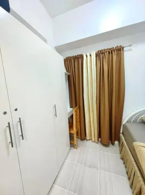 a bedroom with a bed and curtains in a room at Condotel Near Airport Terminals in Manila