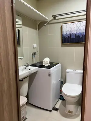 a bathroom with a white toilet and a sink at Twin Duckworth Suites T3 in Manila