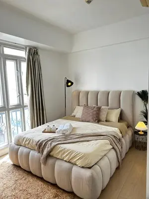 a large bed with a large tufted bed in a bedroom at Tranquil Space Across Airport NAIA 3 in Manila