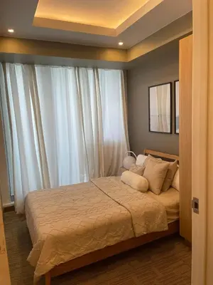 a bedroom with a bed with white curtains at KYH STAYCATION 2BR by Azure Residences Near Airport in Manila