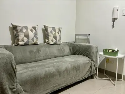 a couch with two pillows on it in a living room at New Oasis Staycation Shore 2 in Manila