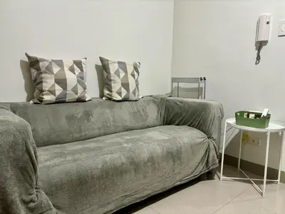 a couch with two pillows on it in a living room at New Oasis Staycation Shore 2 in Manila