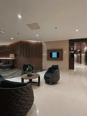 a lobby with chairs and a table and a tv at 1BR Shore Residences near Mall Of Asia in Manila