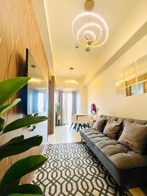 a living room with a couch and a table at Stunning Suite with Balcony near MOA in Manila