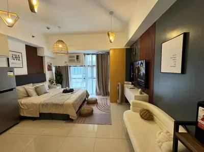 a bedroom with a bed and a living room at Studio Unit McKinley Hill Taguig cd21H in Manila