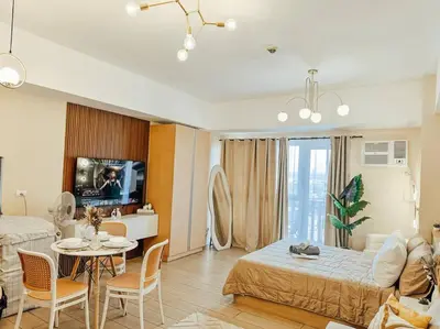 a living room with a bed and a table with chairs at Venice Luxury Residences Studio Taguig City in Manila