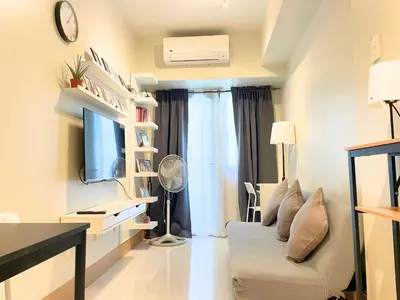 a small living room with a couch and a tv at Callie's Cozy Home at Shore 3 Mall of Asia in Manila