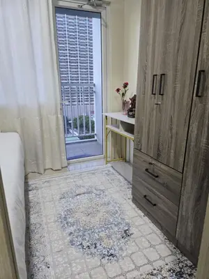 a bedroom with a large wooden cabinet and a window at 1554 Apartel Breeze Resident in Manila