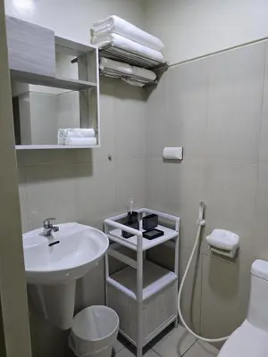 a white bathroom with a sink and a toilet at 1554 Apartel Breeze Resident in Manila