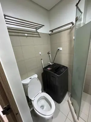 a bathroom with a toilet and a black trash can at M&M Condostay at Shore 2 Residences Tower 2 in Manila