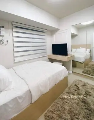 a bedroom with a large bed and a television at Luxe 3BR unit in the heart of BGC Taguig in Manila