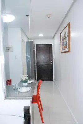 a dining room with a table and a red chair at Brianna's haven property rental in Manila