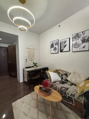 a living room with a couch and a table at R7 Premier Suites - 1 bedroom in Air Residences in Manila