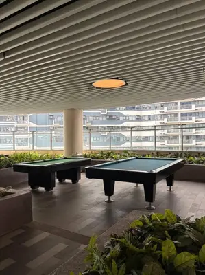 two ping pong tables in a room with a large window at R7 Premier Suites - 1 bedroom in Air Residences in Manila