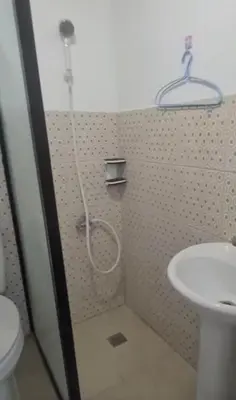 a bathroom with a shower and a toilet and a sink at Js Guest House in Imus