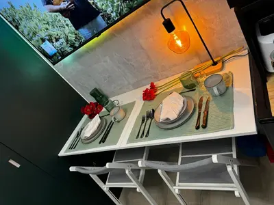 a table with plates and utensils on it at Evergreen suite- 1 bed 1 sofa bed, light sync TV in Manila