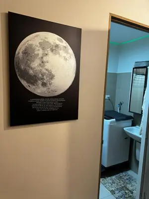 a picture of the moon hanging on a bathroom wall at Evergreen suite- 1 bed 1 sofa bed, light sync TV in Manila