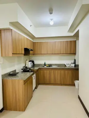 a kitchen with wooden cabinets and a counter top at FAIRLANE residences in Manila