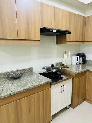 a kitchen with wooden cabinets and a stove top oven at FAIRLANE residences in Manila