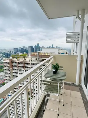 a balcony with two chairs and a view of the city at FAIRLANE residences in Manila