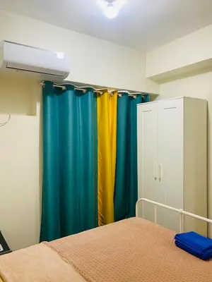 a bedroom with colorful curtains and a bed at Fairlane Residences in Manila