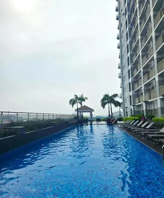a large swimming pool next to a building at Coast Residences - 1 Bedroom with Balcony near PICC, WTC, Star City & MOA in Manila
