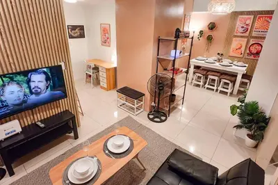 a living room with a tv and a table at Spacious Pool View 2br 2bath Apt in Makati in Manila