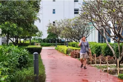 a woman walking down a path in a park at Spacious Pool View 2br 2bath Apt in Makati in Manila