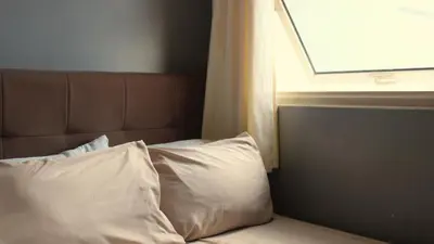 a bed with two white pillows and a window at SMDC Coast Residences in Manila