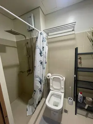 a bathroom with a toilet and a shower curtain at Red Residences Chino Roces Makati in Manila