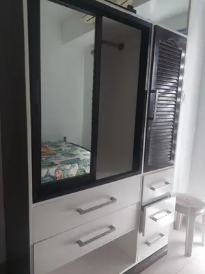 a white dresser with a large mirror and a stool at 2BR SEA RESIDENCES By ELSIE D in Manila
