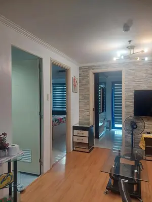 a living room with a table and a television at 2BR SEA RESIDENCES By ELSIE D in Manila