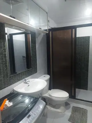 a bathroom with a toilet and a sink and a mirror at 2BR SEA RESIDENCES By ELSIE D in Manila