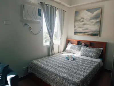 a small bedroom with a bed with a window at Happy Stays D - 300mbps - 65