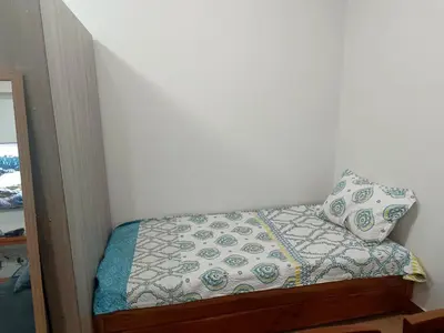 a small bed in a room with a pillow at Happy Stays D - 300mbps - 65