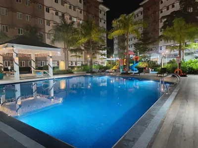 a pool at night with a playground and buildings at Happy Stays D - 300mbps - 65