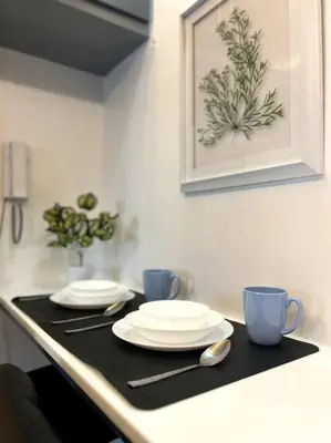 a kitchen counter with two plates and two cups at Casa Cintores Condo near PICC with FREE parking in Manila