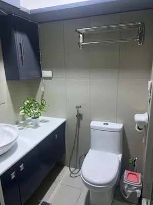 a bathroom with a white toilet and a sink at Casa Cintores Condo near PICC with FREE parking in Manila