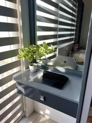 a desk with a keyboard and a laptop in a window at Casa Cintores Condo near PICC with FREE parking in Manila