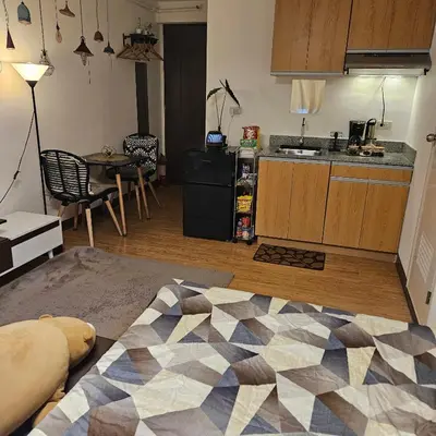 a living room with a kitchen and a table at Mench Staycation in Manila