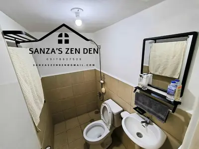 a small bathroom with a toilet and a sink at Modern 2BR Condo with Terrace,Netflix,Pool,& WiFi in Imus