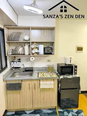 a kitchen with a sink and a microwave at Modern 2BR Condo with Terrace,Netflix,Pool,& WiFi in Imus