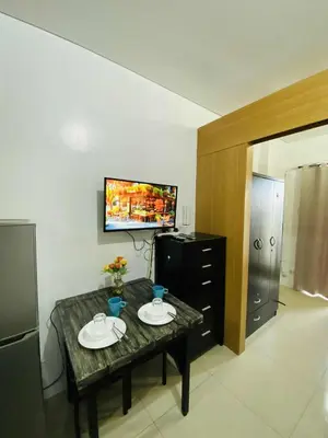 a living room with a table and a television at SD 2 staycation in Manila