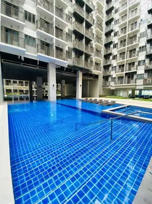a large swimming pool in the middle of a building at 1 Bedroom with Balcony near Mall of Asia in Manila